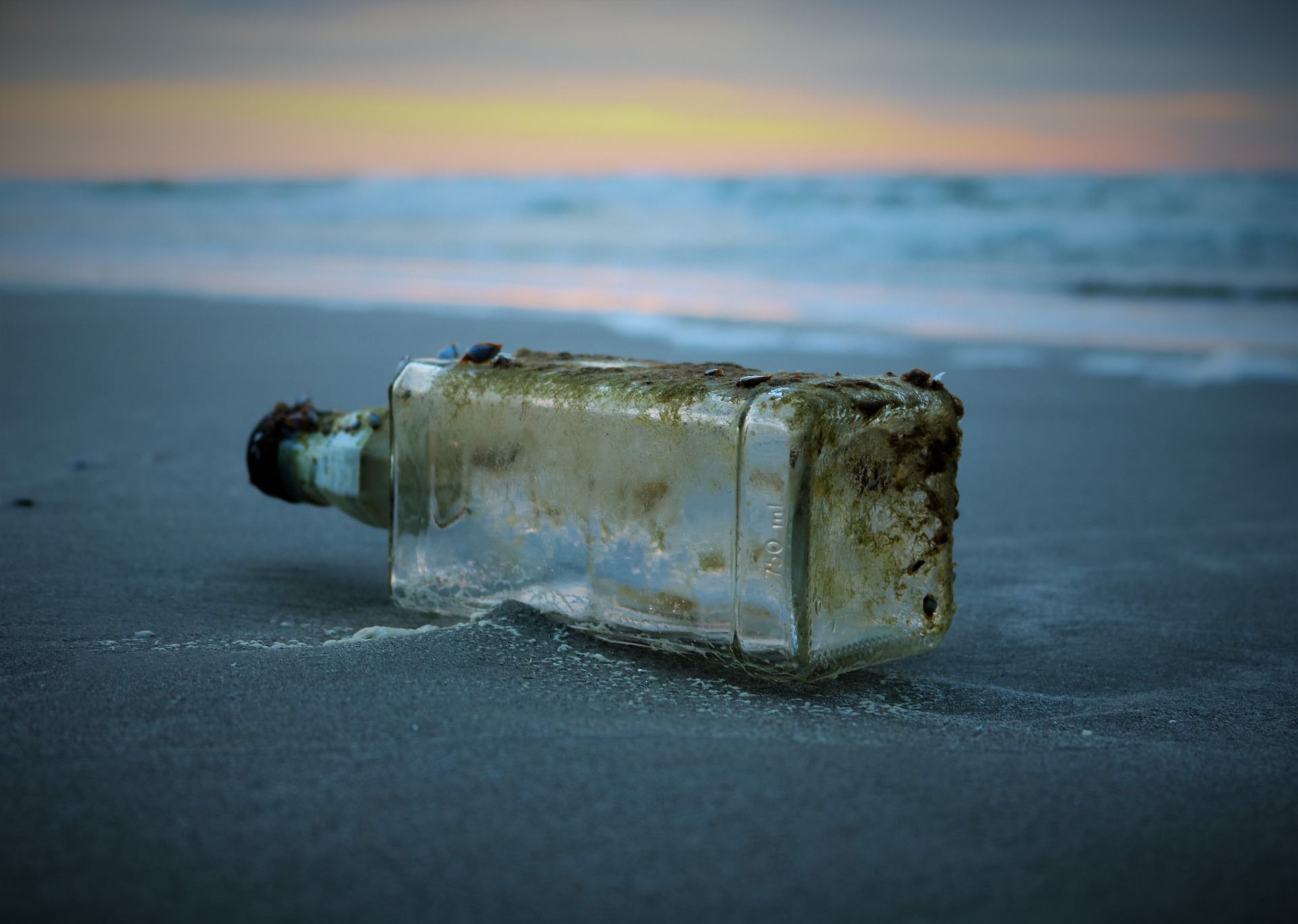 Empty alcohol bottom near the ocean.